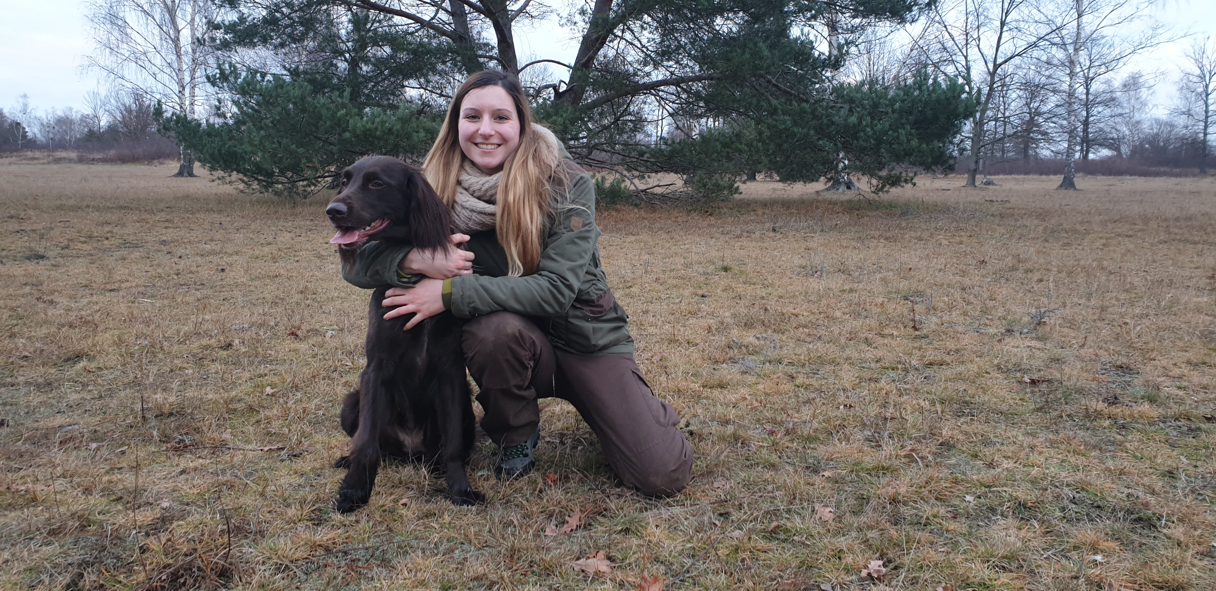 Anna Große mit ihrem Hund auf einer Wiese – warmes Winterlicht
